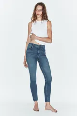 Jeans de tiro alto con corte skinny y largo tobillero. Presenta diseño clásico de cinco bolsillos, cierre frontal con cremallera y botón, con un acabado de lavado azul medio.