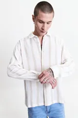 Camisa de manga larga Mistral con diseño de rayas verticales en tonos beige y gris. Presenta una textura tipo waffle, cuello clásico y cierre frontal con botones.