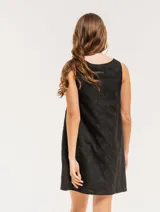 Vestido corto color crema con bordado de lunares negros, sin mangas y con escote redondo.