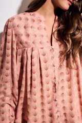 Blusa de corte oversize con estampado de abanicos, cuello redondo con pequeña abertura frontal, cierre de botones y mangas largas con puños elásticos.