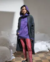 Capucha de lana merino afieltrada color uva, con capucha amplia y bolsillos frontales.