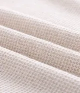 Polo de manga corta con textura en relieve, cuello tipo polo con abertura frontal sin botones y detalles de líneas contrastantes en cuello y puños.