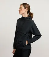 Campera deportiva cortaviento de mujer, de color negro, con capucha, cierre frontal con cremallera y bolsillos laterales.