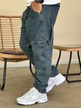 Pantalón tipo carpenter de denim azul con corte holgado, bolsillos laterales utilitarios y cierre frontal con botón.