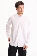 Camisa de lino blanca de manga larga, con cuello camisero clásico y cierre frontal de botones.