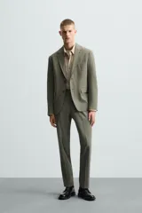 Blazer de corte regular fit confeccionado en tejido con lana, con cuello de solapas de muesca, cierre frontal de un botón, bolsillos de solapa en la cadera y bolsillo de vivo en el pecho.