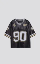 Camiseta estilo jersey de fútbol americano, color negro, con cuello en V ribeteado en blanco y dorado. Presenta el número "90" grande en el frente con borde blanco y dorado. Tiene inscripciones bordadas en el pecho como "L.A." y "Ravers", y el número "9" en la manga.