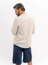 Camisa de manga larga de Cuatroases, de corte clásico con cuello mao y cierre frontal de botones, con patrón de rayas verticales.
