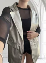 Chaleco largo dorado con textura simil piel de reptil, solapas y bolsillos delanteros.