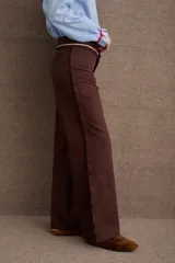 Pantalón de vestir azul marino de corte recto y tiro alto, con detalle de volados en la cintura y cierre frontal.