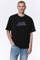 Remera de algodón color negro con cuello redondo y mangas cortas. Presenta un estampado frontal con el logo de la banda Black Sabbath en color violeta.