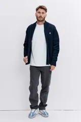 Pantalón de jean corte regular, color gris oscuro, con diseño de cinco bolsillos y cierre frontal con botón y cremallera.