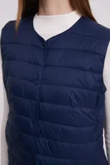 Chaleco acolchado color verde militar con cierre de botones a presión.