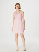 Vestido corto de estilo cruzado con breteles finos y escote en V. Presenta un diseño minimalista con ajuste lateral mediante lazo.
