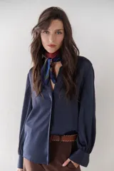 Camisa azul marino de satén con cuello clásico, cierre frontal con botones y mangas largas con puños abotonados.