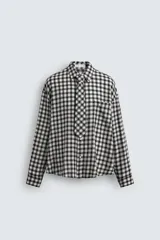 Camisa de corte relajado confeccionada en tejido fluido con estampado de cuadros. Presenta cuello solapa, cierre frontal de botones, manga larga con puños abotonados y una corbata integrada del mismo tejido.