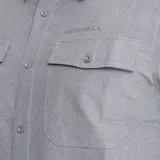 Camisa de manga corta Merrell, color gris cemento, con cuello clásico, cierre frontal de botones y dos bolsillos frontales con solapa en el pecho. Presenta un diseño funcional con tejido técnico transpirable.