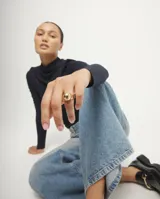 Anillo de aleación de metales bañado en oro 18k, con diseño de banda ancha y una forma de bola en la parte superior.