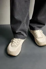Zapatilla deportiva barefoot de hombre, confeccionada en combinación de piezas de piel con acabado serraje en color marrón, con cordones y suela fina de goma en contraste.
