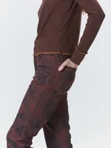 Polera de cuello alto confeccionada en tela rib color blanco, con mangas largas y hombreras. Presenta pespuntes en contraste en las terminaciones del cuello, hombros y puños.