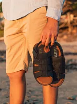 Sandalias de hombre tipo fisherman, con tiras anchas de cuero entrelazadas en color negro y suela marrón.