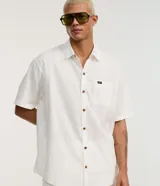Camisa de corte relajado para hombre, confeccionada en una mezcla de cáñamo y algodón. Presenta cuello inglés, mangas cortas, cierre frontal con botones y un bolsillo de parche en el pecho con una pequeña etiqueta de la marca Ripping.