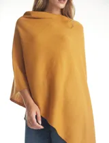 Poncho tejido de punto con diseño asimétrico y aberturas laterales para los brazos.