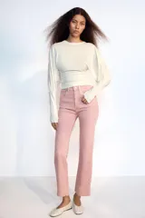 Jeans de tiro alto con cinco bolsillos, diseño cropped flare y bajo sin costuras. Cuenta con cierre frontal de cremallera y botón metálico.