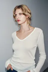 Camiseta blanca de manga larga, corte slim fit y escote pico pronunciado. Tejido ligero y ligeramente transparente con textura acanalada.