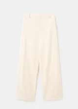 Pantalón de tiro alto color crudo, con diseño largo y corte recto. Cuenta con trabillas, bolsillos laterales y cierre frontal oculto con cremallera, botón y ganchos.