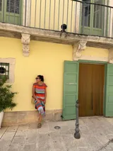 Vestido largo de tejido de punto, con rayas horizontales en tonos tierra, azul y blanco. Presenta cuello redondo, mangas cortas caídas y aberturas laterales en el ruedo.