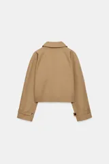 Chaqueta corta de cuello subido y manga larga con trabilla y botón. Cuenta con bolsillos de vivo en el delantero y cierre frontal con botones.