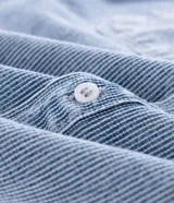 Camisa masculina de jeans celeste con estampa de rayas verticales, corte boxy, cuello inglés, manga corta, cierre abotonado y bolsillos frontales.