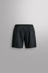 Pantalón corto deportivo color marrón oliva, confeccionado en tejido técnico ligero y elástico, con forro interior. Presenta cintura elástica ajustable con cordón, bolsillos frontales, bolsillo de seguridad trasero con cierre y aberturas laterales en el bajo.
