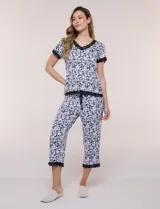 Pijama con capri René Rofé, compuesto por una remera de manga corta con escote en V y un pantalón capri con cintura elastizada y cordón de ajuste. Ambas prendas presentan un estampado floral en blanco y negro, con detalles de encaje negro en el escote, mangas, ruedo de la remera y dobladillo del pantalón.