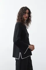 Sweater de tejido de punto con silueta recta y calce relajado. Presenta un diseño liso en color negro con detalles de vivos en contraste color blanco en el cuello redondo, los puños y el ruedo.