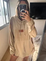 Buzo de plush oversize color fucsia, con capucha y cordones.