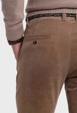 Pantalón de pana gris con corte slim fit, bolsillos laterales y traseros, y cinturón trenzado verde.