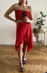 Top color crudo, sin mangas, con frunces en el busto y volados en el ruedo.