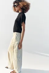Top de punto pointelle color negro, con cuello redondo y mangas cortas anchas de diseño holgado.