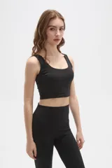 Top deportivo de bretel ancho, color negro, con cuello redondo profundo y diseño ajustado al cuerpo.