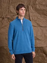 Fleece de algodón color gris melange, con cuello alto y cierre frontal parcial. Diseño de manga larga con puños y ruedo acanalados.