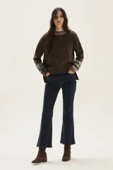 Sweater de lambswool color marrón, con cuello redondo vanizado en lila y puños con rayas en tonos pastel. Incluye un detalle de temporada hecho a mano en la espalda.