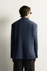 Blazer regular fit azul marino confeccionado en tejido con elasticidad, con cuello de solapas de muesca, cierre frontal con botones y bolsillos con solapa en la cadera.