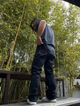 Pantalón negro de gabardina, corte ancho tipo carpenter, con costuras blancas contrastantes.