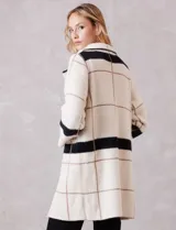 Chaqueta de tejido suave con estampado a cuadros en tonos beige y blanco, cuello con solapa y cierre de botón frontal. Incluye bolsillos delanteros.