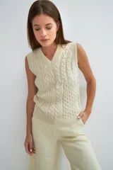 Chaleco de lana color crudo, tejido con escote en V y diseño con diferentes puntos combinados en el frente.