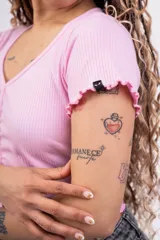 Remera corta de punto canalé color rosa, con escote en V, mangas cortas con volados y cierre frontal con botones.