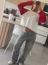 Remera oversize de manga larga estilo raglán, con cuerpo de color marrón y mangas y cuello en tono rosado.