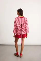 Remerón de algodón a rayas horizontales celestes y rojas, con silueta oversize, cuello redondo y mangas 3/4.